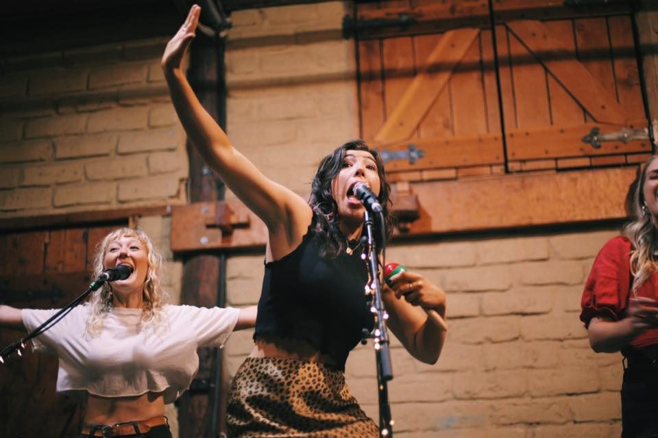 Jess Fairlie mid-song with backing vocalists