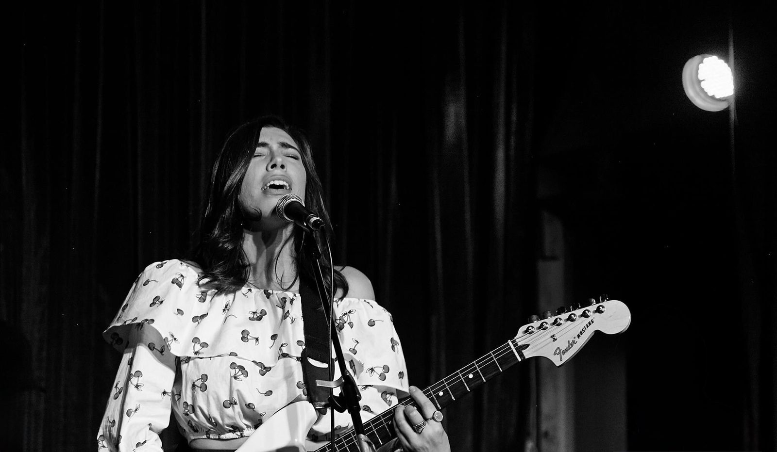 Jess Fairlie playing guitar and singing live